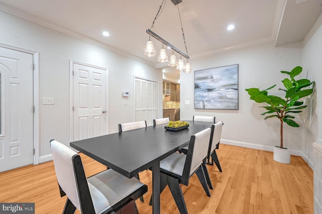 dining area featuring light wood-type flooring and ornamental molding