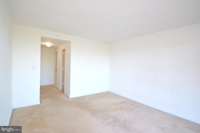 unfurnished room featuring light carpet