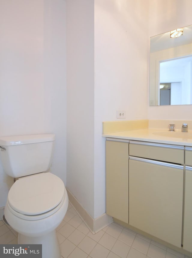 bathroom featuring toilet, tile patterned flooring, baseboards, and vanity