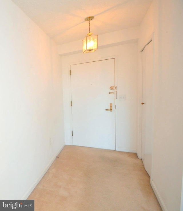 entryway featuring light carpet and baseboards