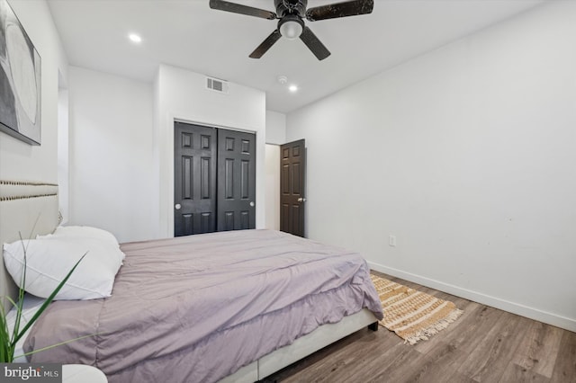 bedroom featuring a closet, wood finished floors, baseboards, a ceiling fan, and recessed lighting