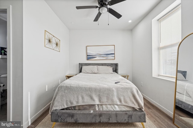 bedroom featuring wood finished floors, baseboards, and a ceiling fan