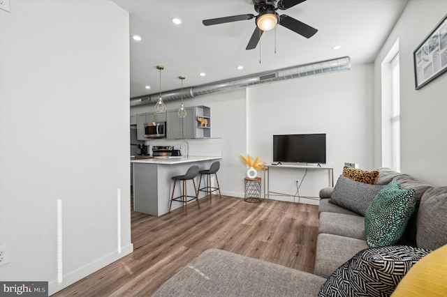 living room with recessed lighting, wood finished floors, baseboards, and a ceiling fan