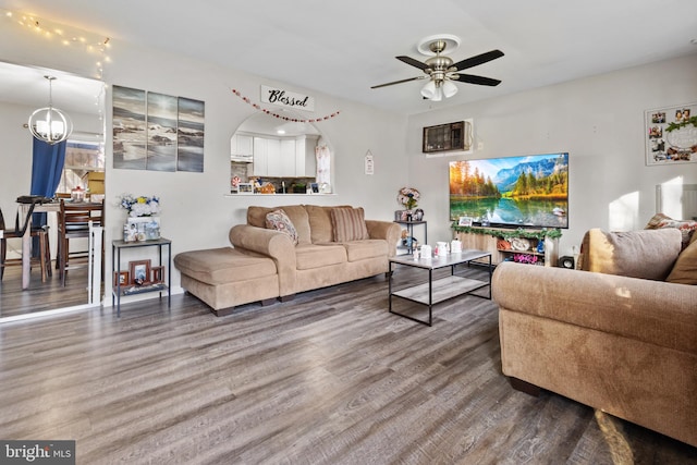 living room featuring wood-type flooring and ceiling fan with notable chandelier