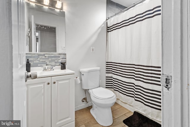 bathroom with curtained shower, backsplash, wood-type flooring, vanity, and toilet