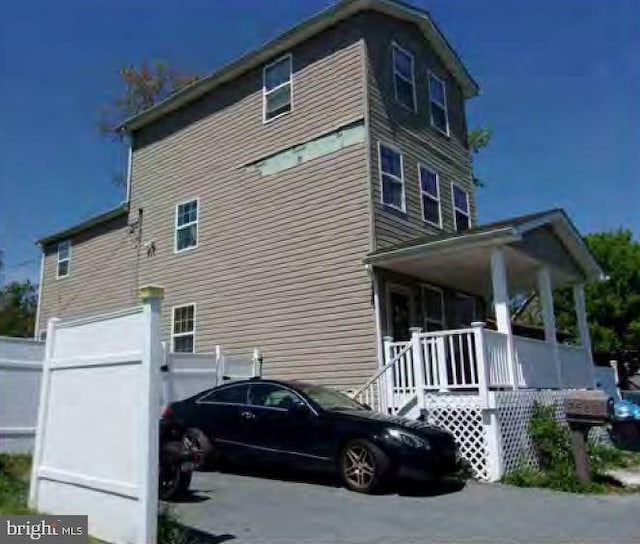 view of property exterior with a garage and covered porch