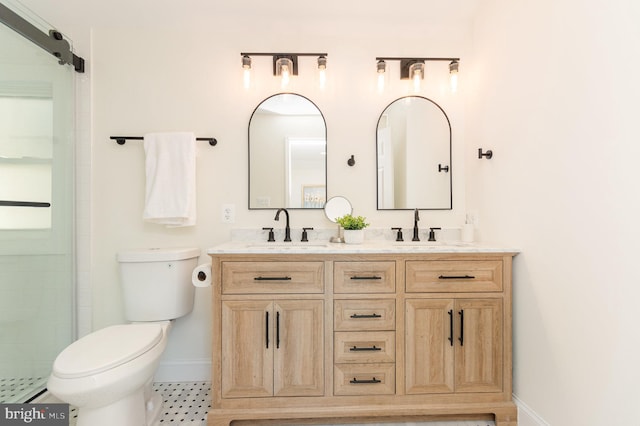 bathroom featuring a shower with shower door, vanity, and toilet