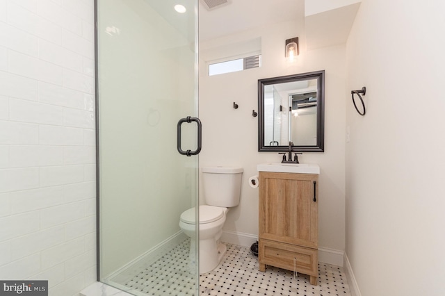 bathroom with toilet, vanity, and a shower with shower door