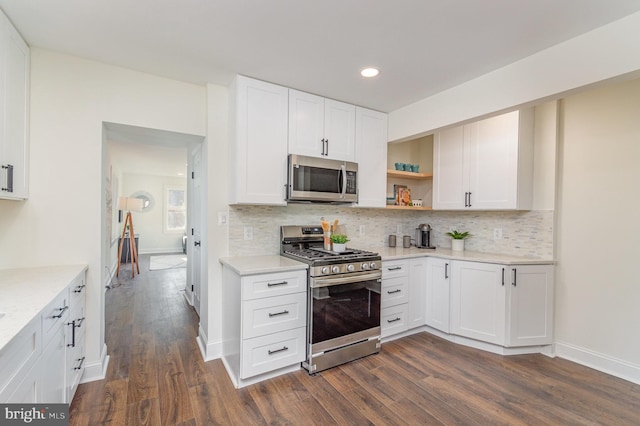 kitchen featuring stainless steel appliances, white cabinets, dark wood-type flooring, and backsplash