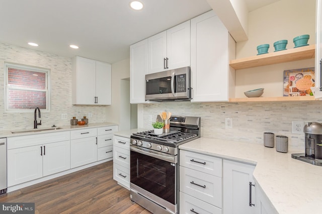 kitchen with dark hardwood / wood-style flooring, sink, light stone countertops, white cabinetry, and appliances with stainless steel finishes