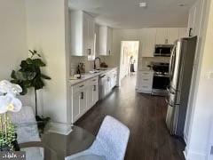 kitchen featuring white cabinetry, appliances with stainless steel finishes, dark hardwood / wood-style floors, and sink