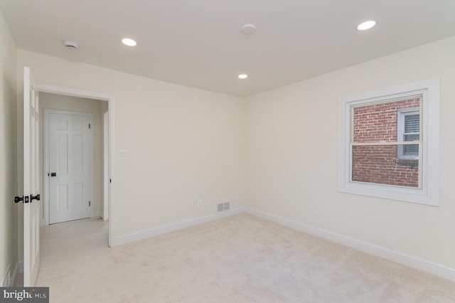 spare room featuring light carpet