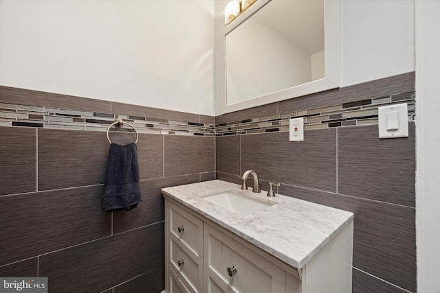 bathroom with vanity and tile walls