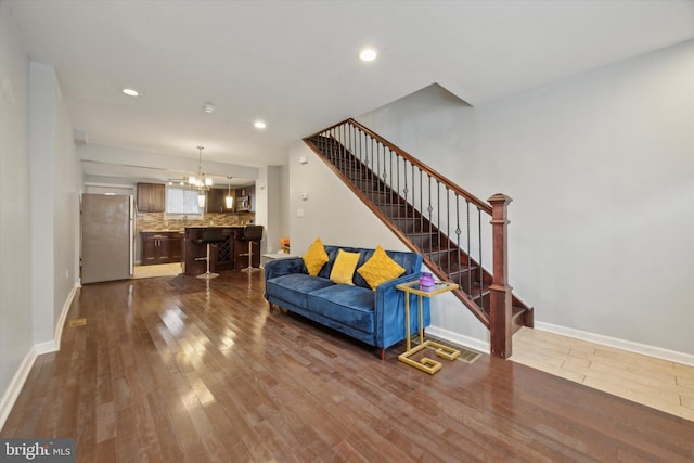 living room with dark hardwood / wood-style floors and an inviting chandelier