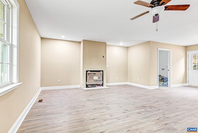 unfurnished living room featuring light hardwood / wood-style flooring and ceiling fan