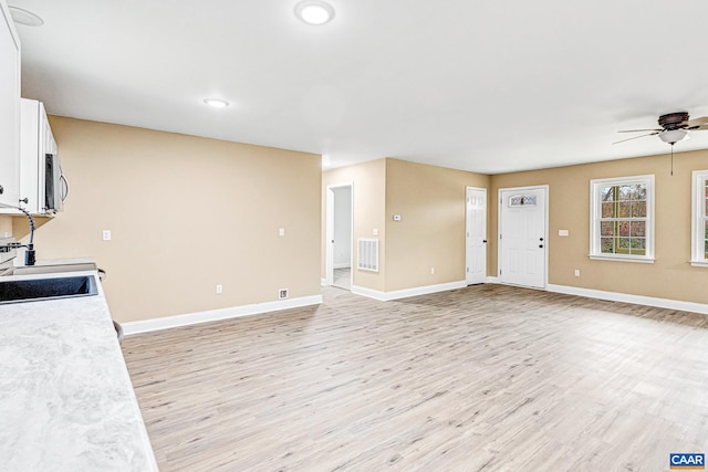 kitchen featuring ceiling fan, light hardwood / wood-style floors, white cabinetry, and sink