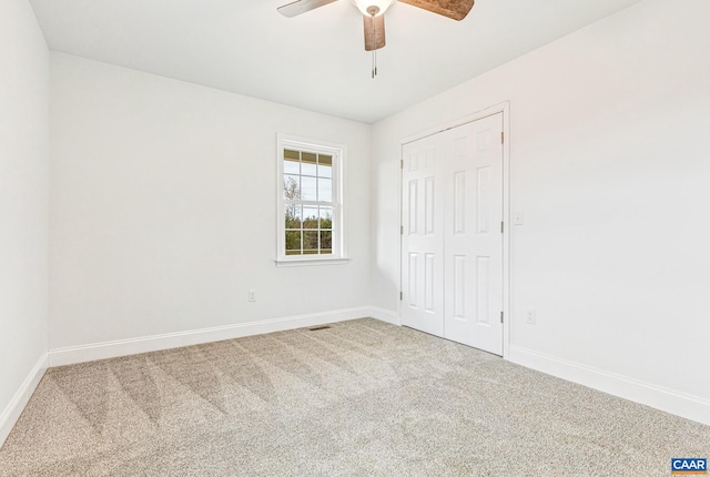 unfurnished bedroom featuring ceiling fan, a closet, and carpet floors