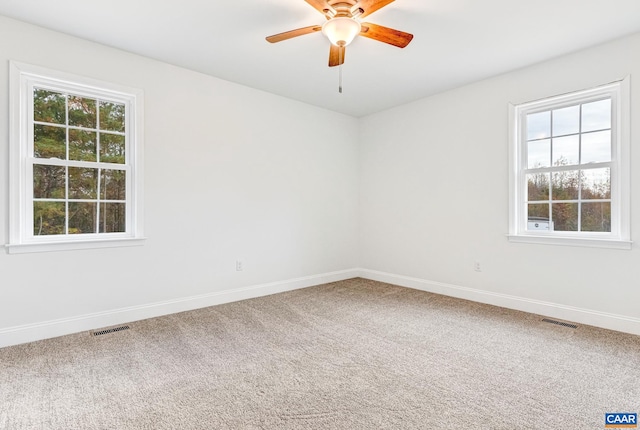 spare room featuring carpet flooring, ceiling fan, and a healthy amount of sunlight