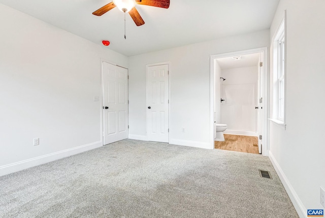 unfurnished bedroom with carpet flooring, ensuite bath, and ceiling fan