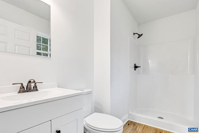 bathroom with walk in shower, vanity, wood-type flooring, and toilet