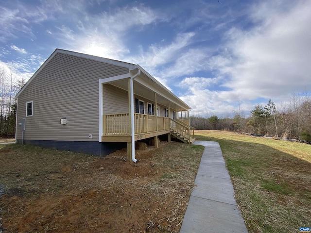 view of property exterior with covered porch and a yard