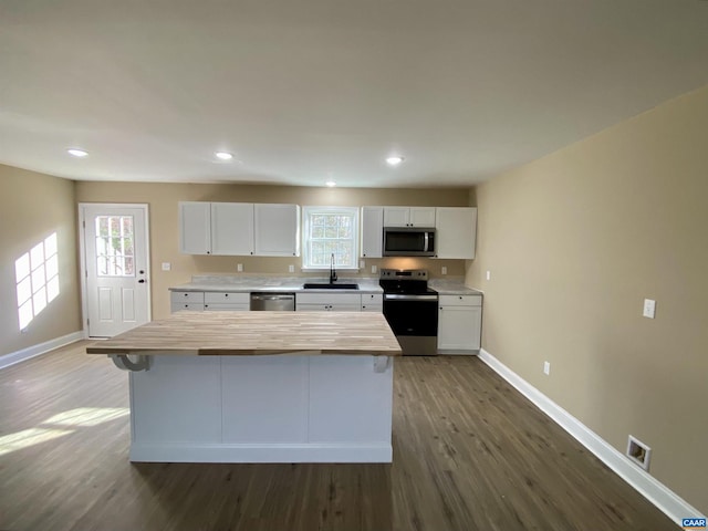 kitchen with sink, white cabinets, stainless steel appliances, and dark hardwood / wood-style floors