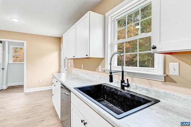 kitchen featuring white cabinetry, dishwasher, sink, and light hardwood / wood-style floors