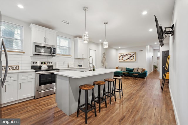 kitchen featuring appliances with stainless steel finishes, hardwood / wood-style flooring, and white cabinetry