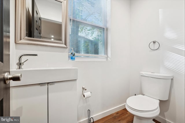 bathroom with hardwood / wood-style floors, vanity, and toilet