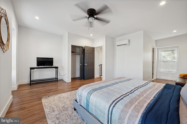 bedroom with an AC wall unit, ceiling fan, and dark wood-type flooring