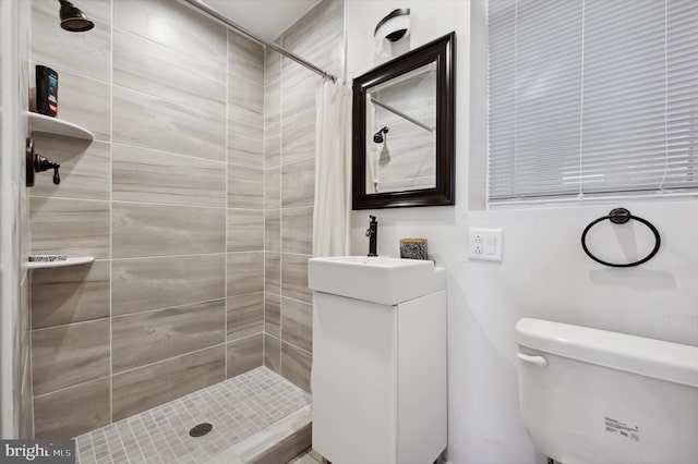 bathroom featuring curtained shower, vanity, and toilet