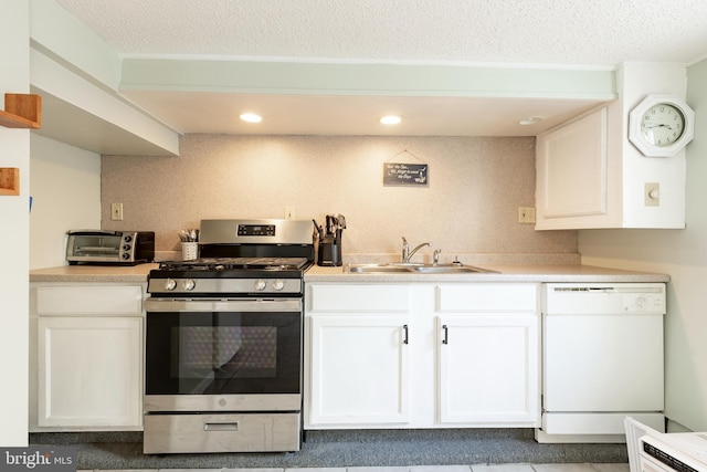 kitchen featuring a textured ceiling, sink, white cabinets, dishwasher, and stainless steel range with gas stovetop