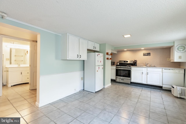 kitchen featuring white cabinetry, a textured ceiling, light tile patterned floors, sink, and white appliances