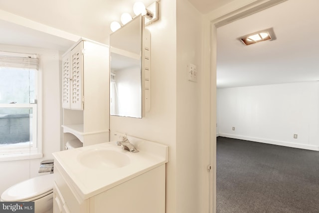 bathroom with plenty of natural light, vanity, and toilet