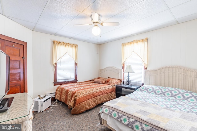 bedroom with ceiling fan, multiple windows, a paneled ceiling, and carpet