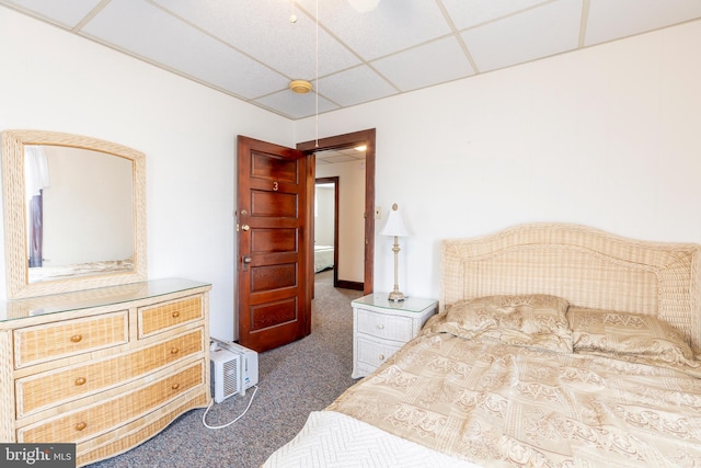 bedroom featuring a drop ceiling and dark carpet