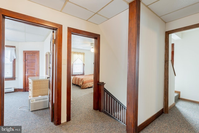 corridor featuring a baseboard heating unit and carpet