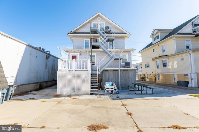 back of property featuring central AC unit, a patio area, and a storage unit