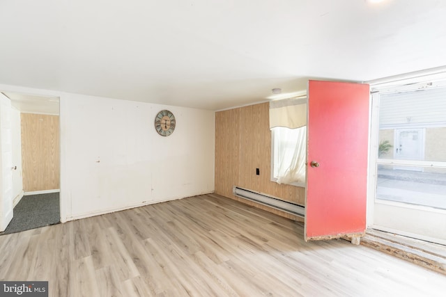 unfurnished room featuring a baseboard radiator and light wood-type flooring