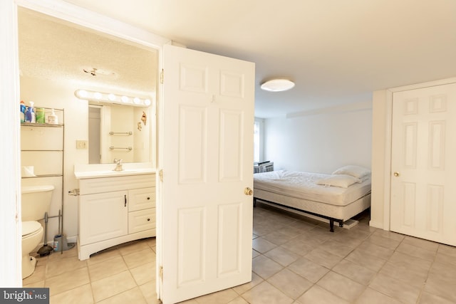 bedroom featuring light tile patterned floors and sink