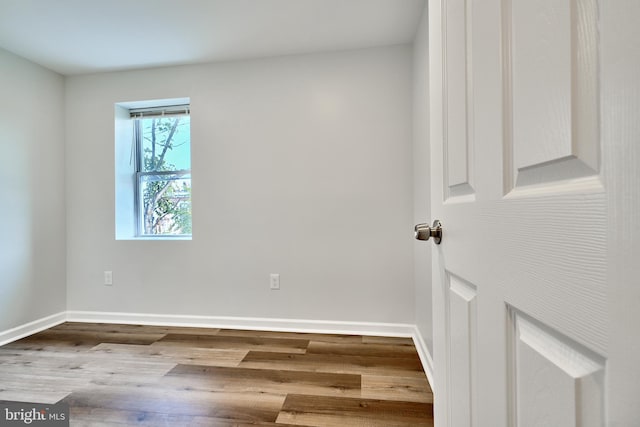 unfurnished room with wood-type flooring