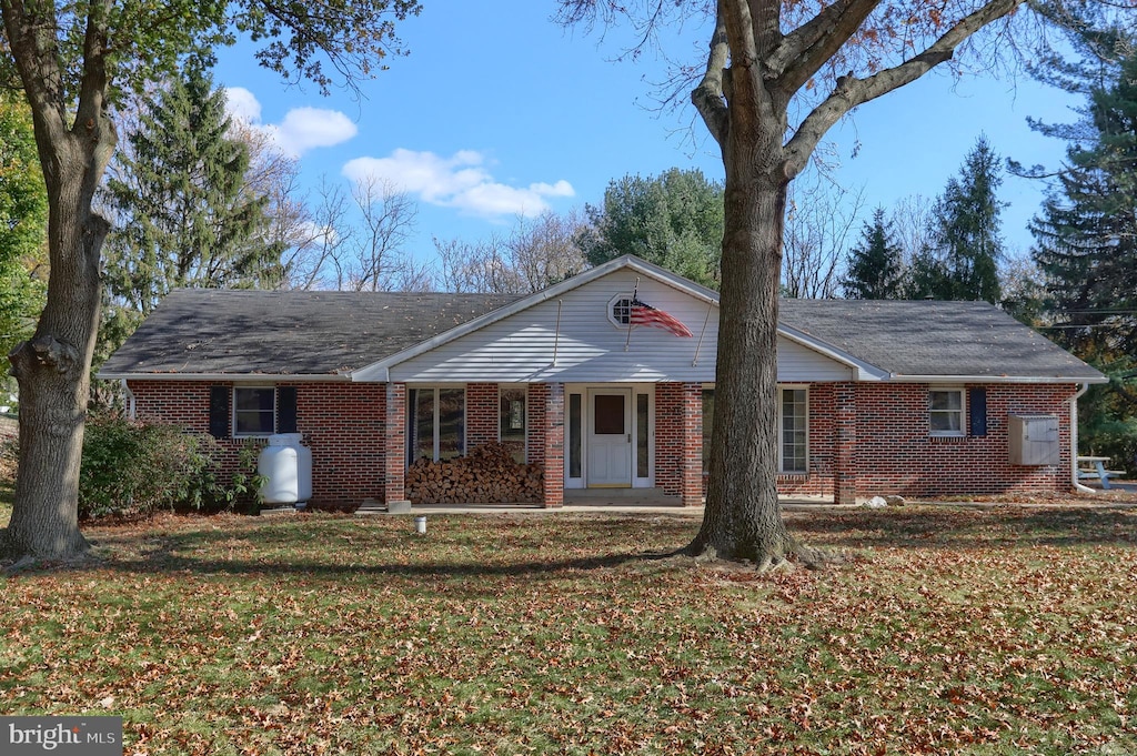 ranch-style house with covered porch and a front lawn