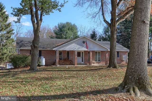 ranch-style home featuring a front lawn and covered porch