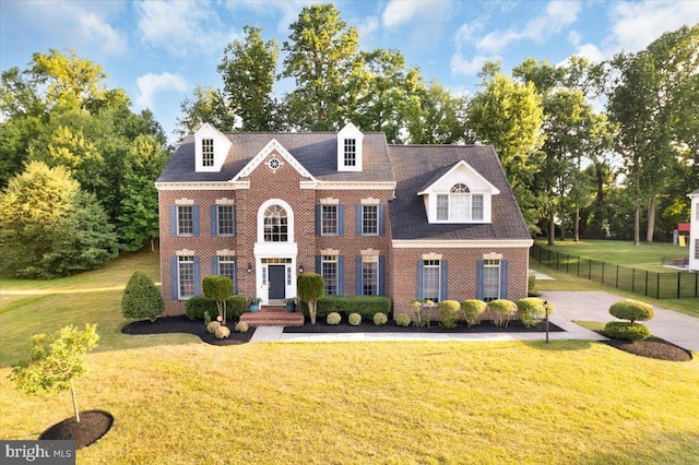 colonial-style house featuring a front lawn