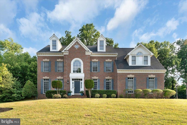 colonial-style house featuring a front yard