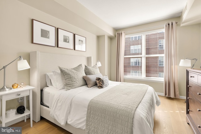 bedroom with multiple windows and light hardwood / wood-style flooring