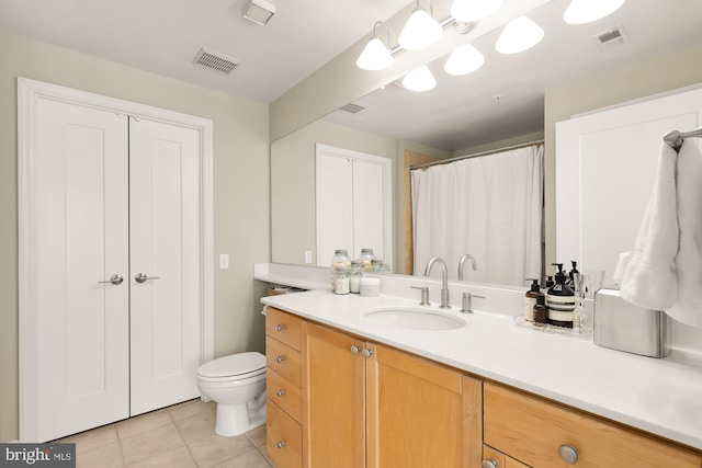 bathroom featuring tile patterned flooring, vanity, and toilet