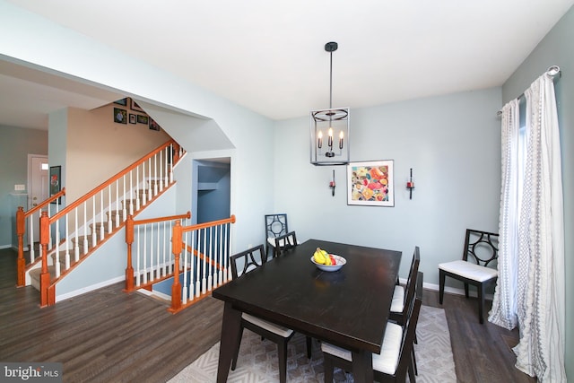 dining space with dark hardwood / wood-style flooring and an inviting chandelier