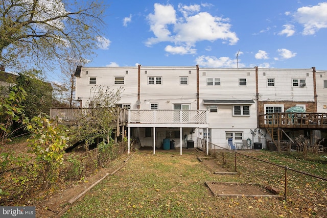 rear view of property with a yard and a deck