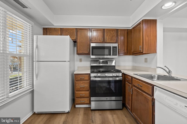 kitchen with light hardwood / wood-style floors, sink, and appliances with stainless steel finishes